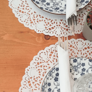 Tovagliette di pizzo sotto piatti e posate dettaglio